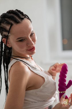 Caucasian woman holding a pink dildo