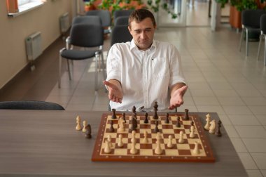 Beyaz adam satranç hamlesi düşünüyor.