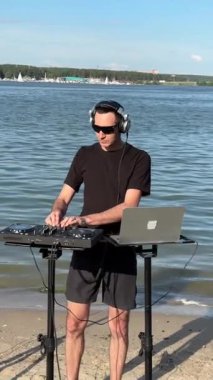 Beyaz adam plajda DJ olarak çalışıyor.