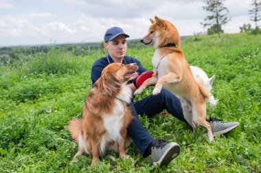 Beyaz bir adam üç köpekle yürür. Köpek gezdirici