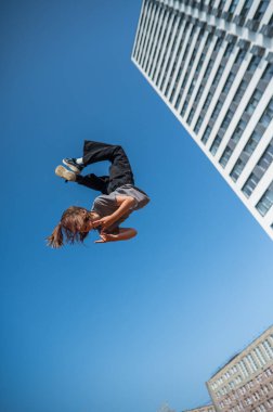 Bir kız trambolinde jimnastik yapıyor.