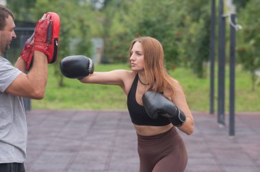 Erkek ve kadın dışarıda idman yapıyor. Boks dersi