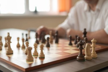 Beyaz adam satranç hamlesi düşünüyor.