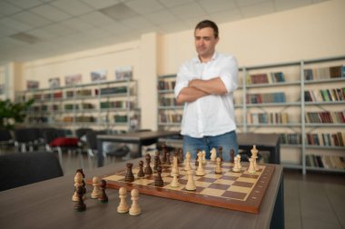 Beyaz adam satranç hamlesi düşünüyor.