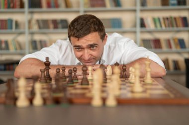 Beyaz adam satranç hamlesi düşünüyor.