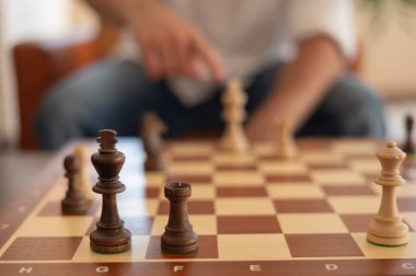 Orta yaşlı beyaz bir adamın satranç oynaması yakındır.