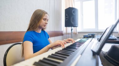Beyaz kadın elektrikli piyano çalıyor.