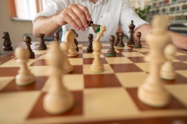 Orta yaşlı beyaz bir adamın satranç oynaması yakındır.