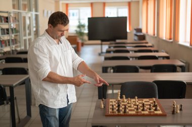 Beyaz adam satranç hamlesi düşünüyor.