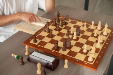 Orta yaşlı beyaz bir adamın satranç oynaması yakındır.