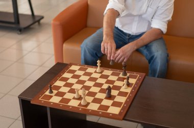 Orta yaşlı beyaz bir adamın satranç oynaması yakındır.