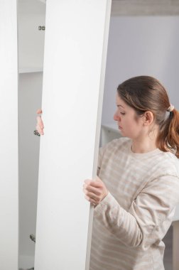 Beyaz bir kadın gardırop hazırlıyor.