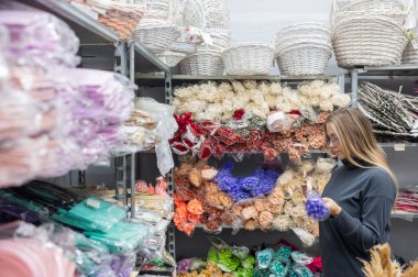 Beyaz bir kadın ev dekoratöründen kurutulmuş çiçek alıyor.