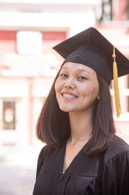 Mezuniyet elbisesi içindeki mutlu Asyalı kadın.