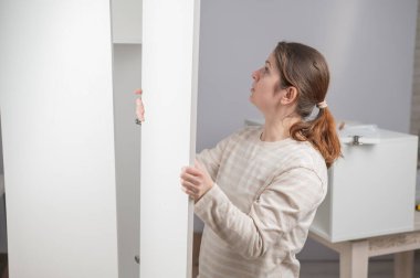 Beyaz bir kadın gardırop hazırlıyor.