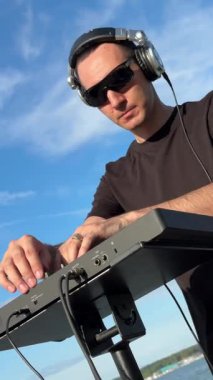 Beyaz adam plajda DJ olarak çalışıyor.