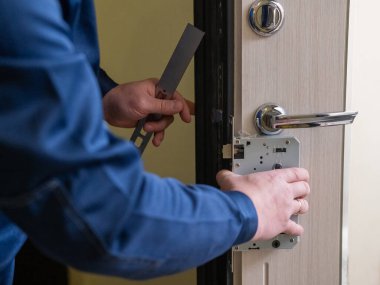 Teknisyen ön kapıya akıllı bir elektronik kilit takıyor.