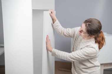 Beyaz bir kadın gardırop hazırlıyor.