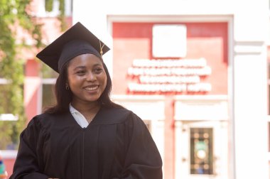 Mezuniyet elbisesi içinde mutlu bir Afrikalı kadın.
