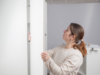 Beyaz bir kadın gardırop hazırlıyor.