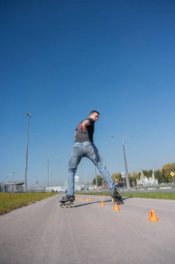 Beyaz bir adam slalom pistinde paten kayıyor.