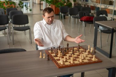 Beyaz adam satranç hamlesi düşünüyor.