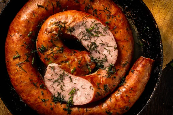 Homemade sausage with herbs in a cast iron pan — Stock Photo, Image