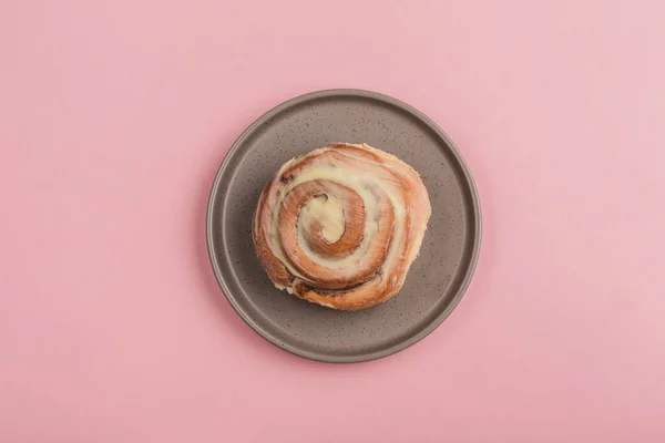 Klassisk Cinnabon Bulle Ligger Tallrik Rosa Bakgrund Ovanifrån Med Kopieringsutrymme — Stockfoto