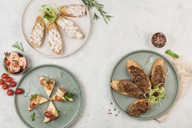 Farklı et ve soslu balıklarla bezenmiş, şefin hafif arka planında akışı olan, üst manzaralı, kopyalanmış tabaklar. Düz yat. Kahvaltı konsepti. Restoran yemekleri..