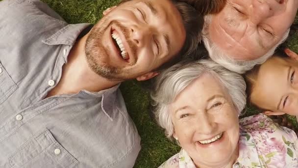 Familia acostada en un jardín — Vídeo de stock