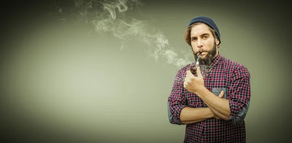 Hipster usando chapéu de malha cachimbo de fumar — Fotografia de Stock