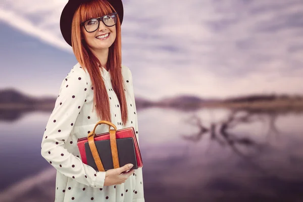 Smiling hipster woman holding book belt — Stock Photo, Image