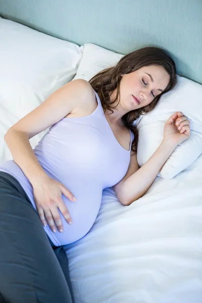 Mujer embarazada durmiendo en el dormitorio — Foto de Stock