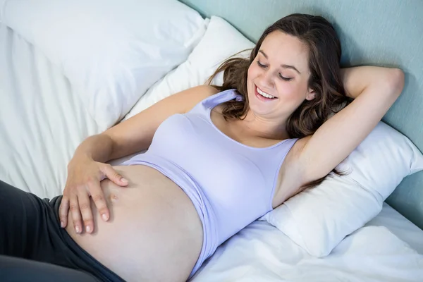 Mulher grávida deitada na cama — Fotografia de Stock