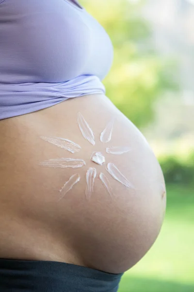 Pregnant woman with cream on her belly — Stock Photo, Image