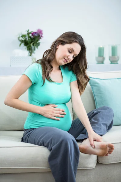 Беременная женщина массирует усталые ноги — стоковое фото