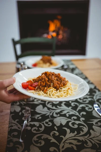 Person putting spaghetti on table — Stock Photo, Image