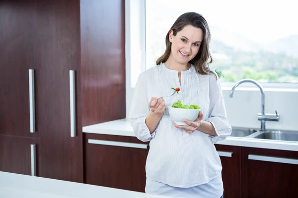 Těhotná žena jíst salát — Stock fotografie
