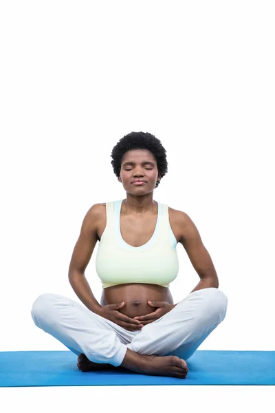 Kobieta w ciąży medytuje na mat — Zdjęcie stockowe