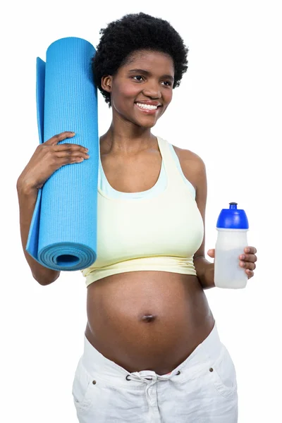 Pregnant woman holding water bottle and mat — Stock Photo, Image