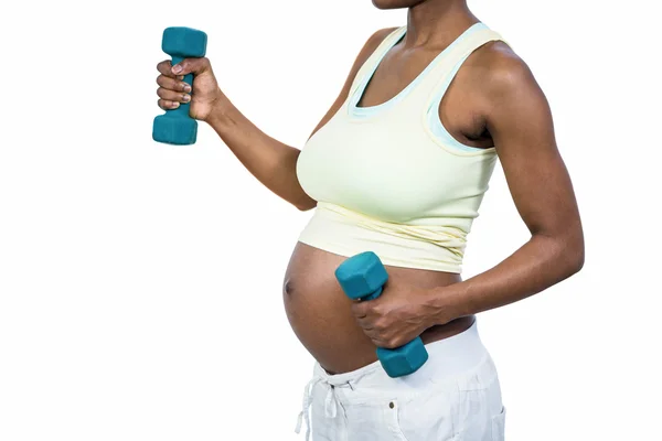Беременная женщина поднимает гантель — стоковое фото