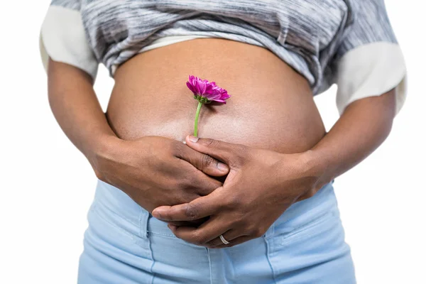 Terhes nő virággal, megérintette a hasa — Stock Fotó