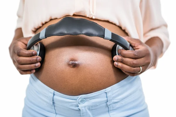 孕妇肚子上抱着耳机 — 图库照片