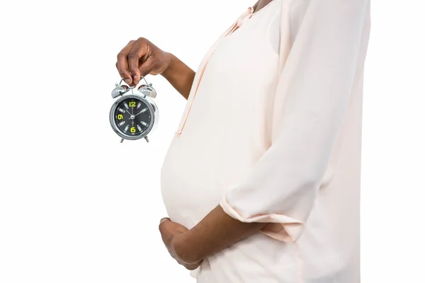 目覚まし時計を保持している妊娠中の女性 — ストック写真