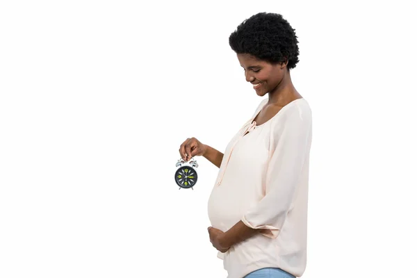Zwangere vrouw met een wekker — Stockfoto