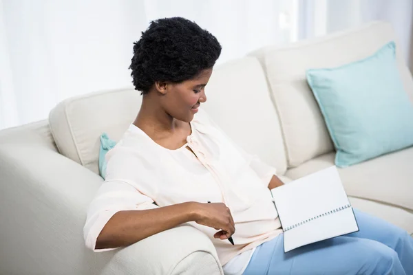 Mujer embarazada sosteniendo cuaderno — Foto de Stock
