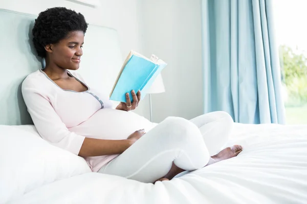 Mujer embarazada leyendo un libro —  Fotos de Stock