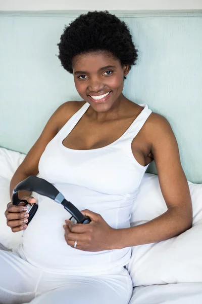 Pregnant woman holding headphone on belly — Stock Photo, Image