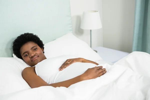 Hamile kadın yatakta dinleniyor — Stok fotoğraf