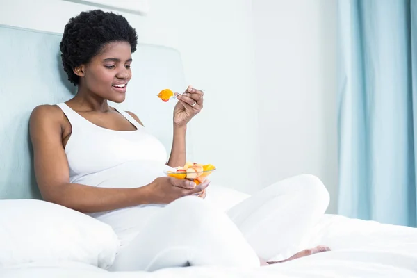 Mujer embarazada comiendo ensalada de frutas —  Fotos de Stock